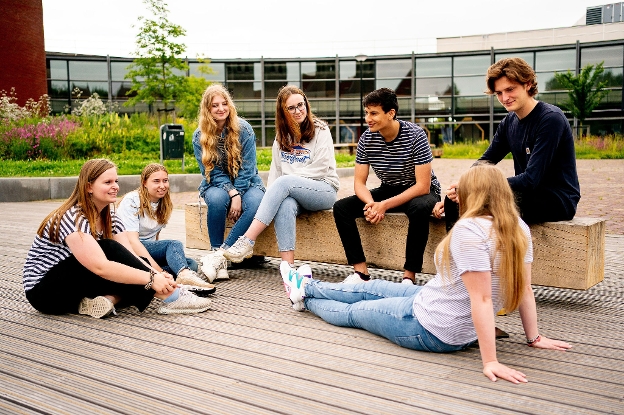 Group of international students chilling out in front of the Leeuwarden Van Hall Larenstein building